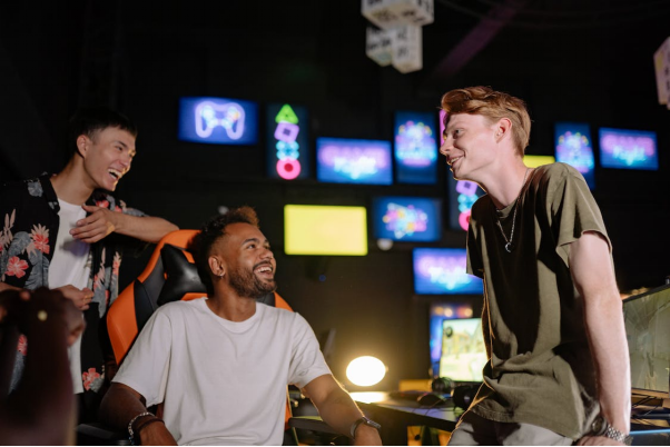 Three gamers are smiling at one another